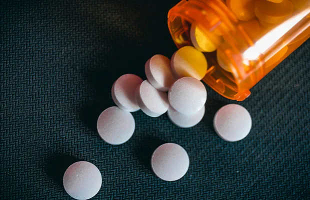 An image of an orange aspirin bottle spilled out on a table.