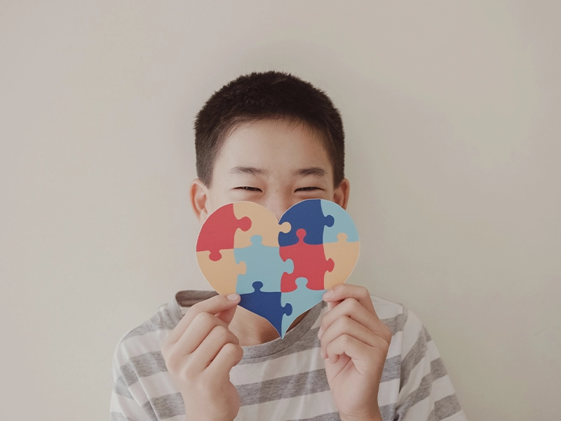 boy holding colorful heart in his hands