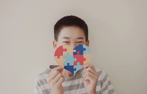 boy holding colorful heart in his hands