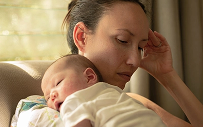 a woman lifting up her little baby
