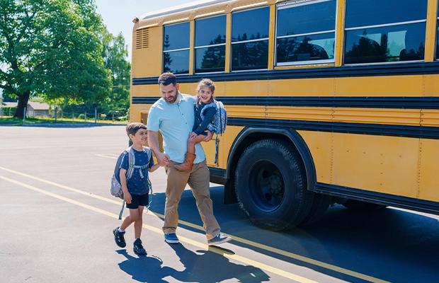 Man walking with his children to take them to the school bus