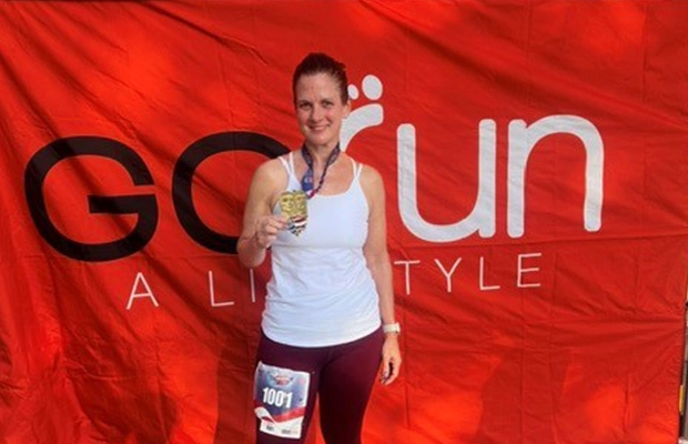 woman showing medal awarded in marathon