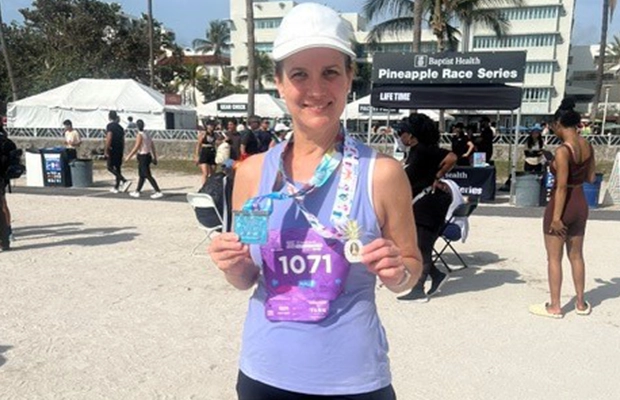 woman showing medal awarded in marathon