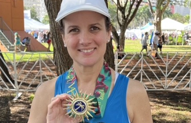 woman showing medal awarded in marathon