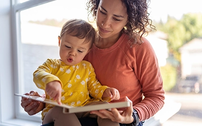 A mother reading a book to her little daughter