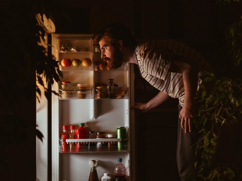 Man looks for food in the refrigerator