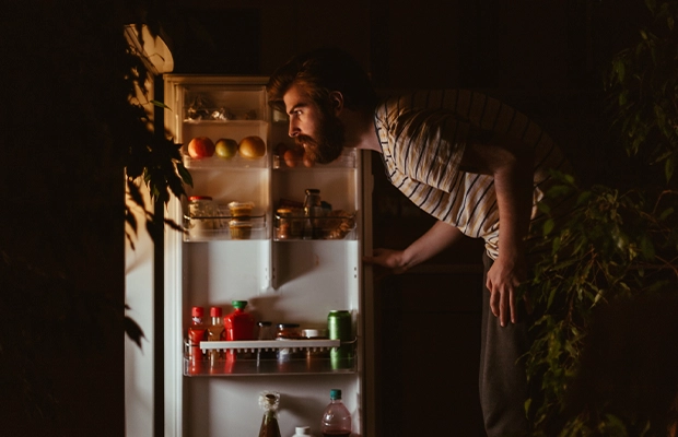 Man looks for food in the refrigerator