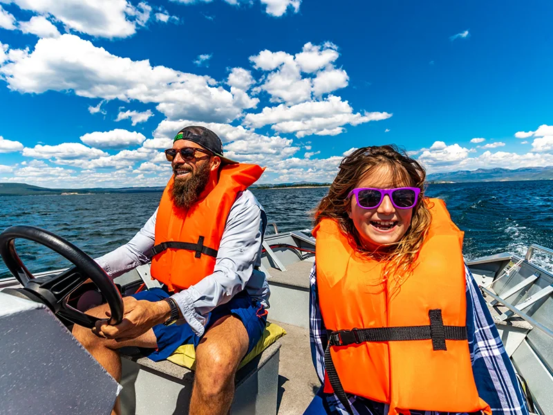 Two people in a boat, they have on life jackets