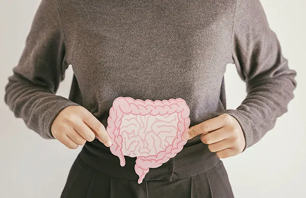 A closeup of a woman holding a cutout of a stomach