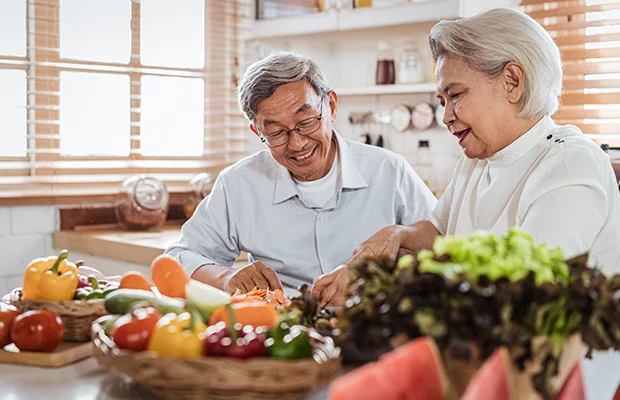 An older couple prepping vegetables in the kitchen