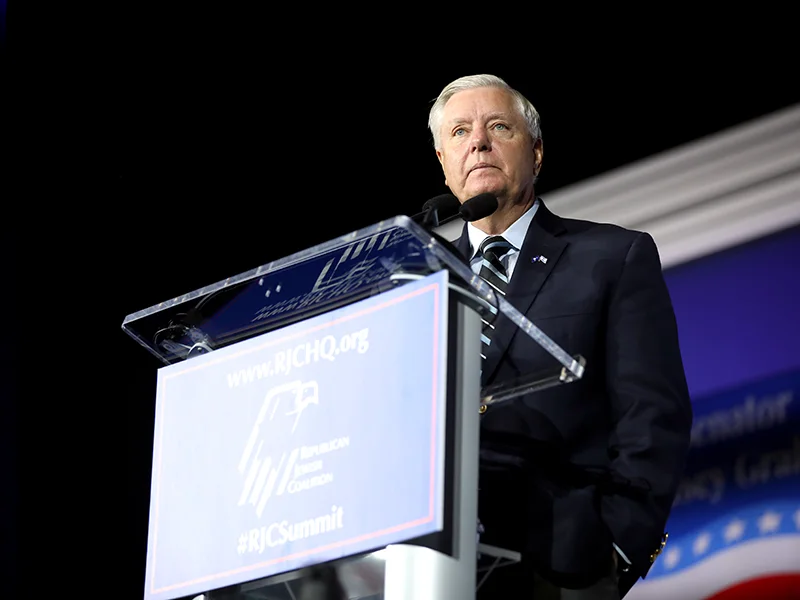 A man in a suit standing behind a podium