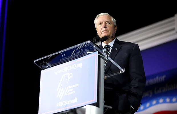 A man in a suit standing behind a podium