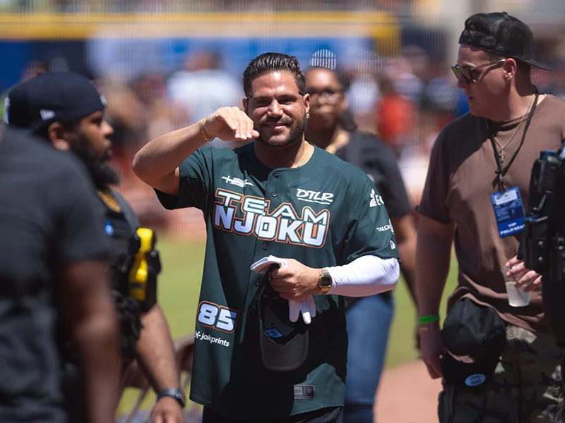 A smiling man in a teal 