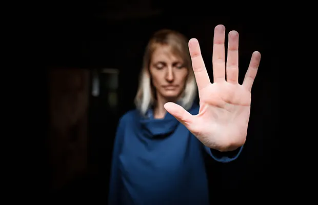 A woman with eyes closed, she has her hand being held out