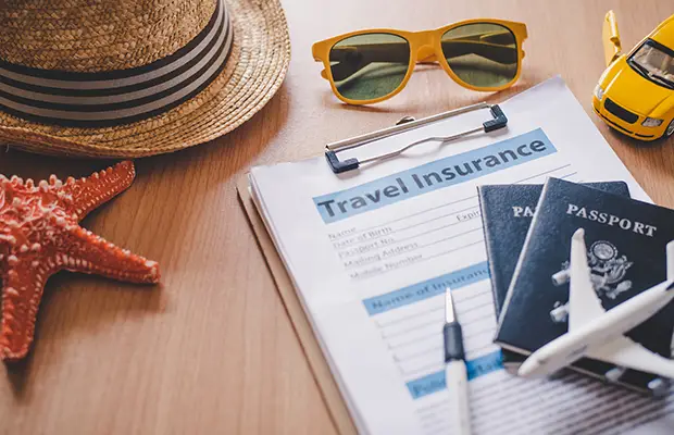 A table with a few items on it; a hat, check list, passport, sunglasses, small model airplane