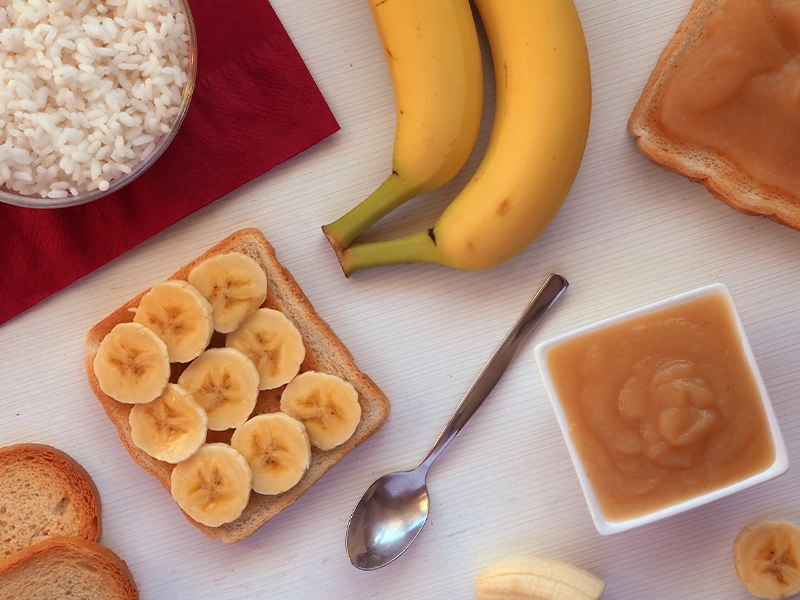 Photograph of a table featuring bananas, rice, peanut butter, and other foods.