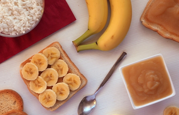 Photograph of a table featuring bananas, rice, peanut butter, and other foods.
