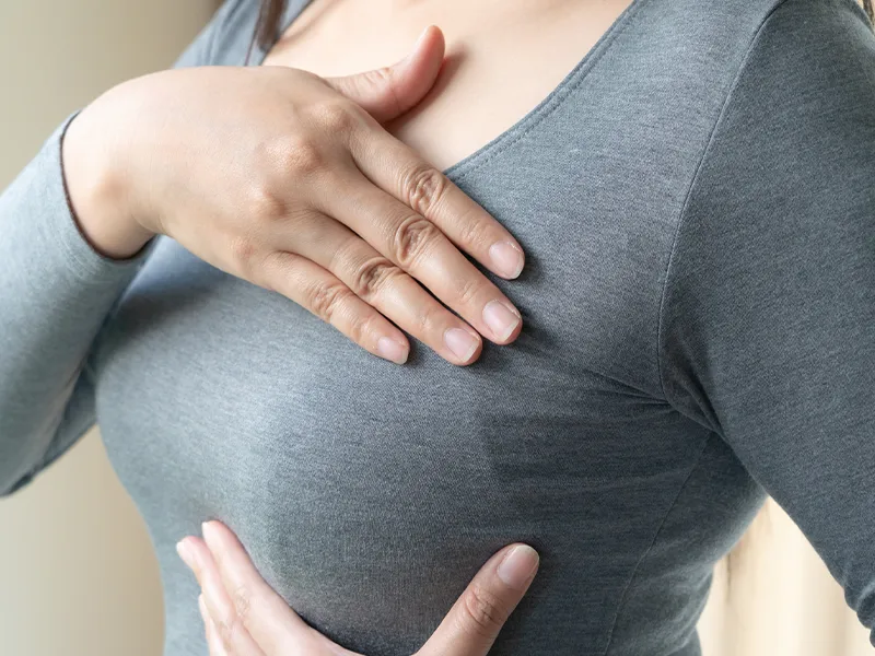 woman performing breast self-examination