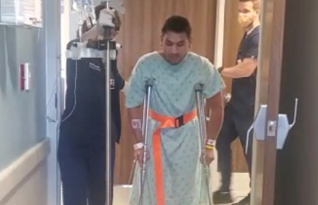 man on crutches walking next to a doctor