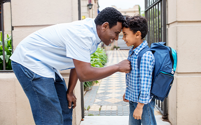 dad and son in front of school