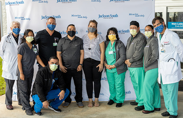 Medical professionals, a men, and woman, wearing face masks and taking a picture