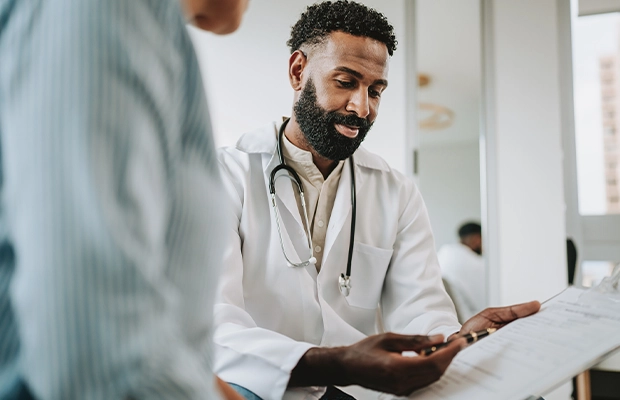 An image of a person seen from behind talking to a doctor.