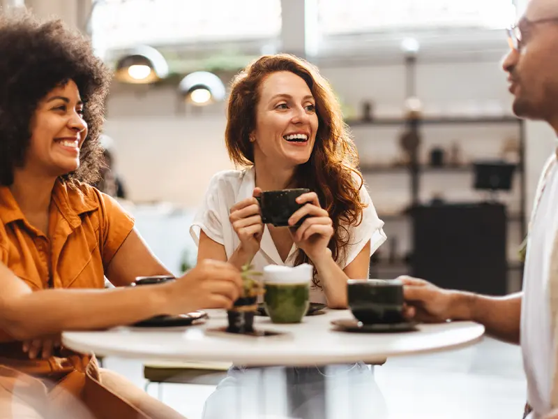 Women smiling while drinking coffee in a cafe