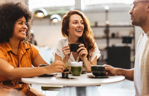 Women smiling while drinking coffee in a cafe
