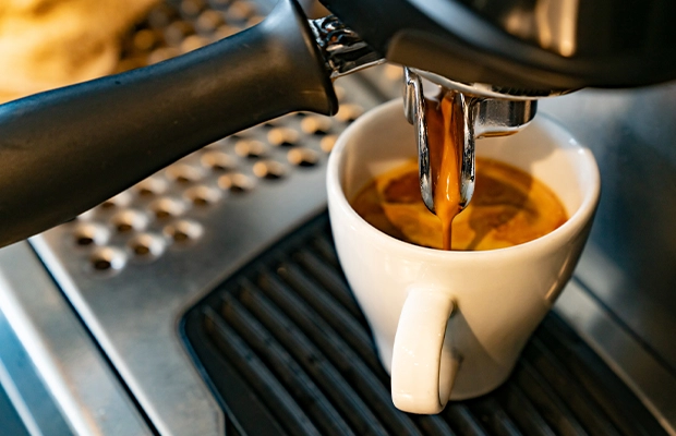 Close-up of coffee being poured from a coffee pot.