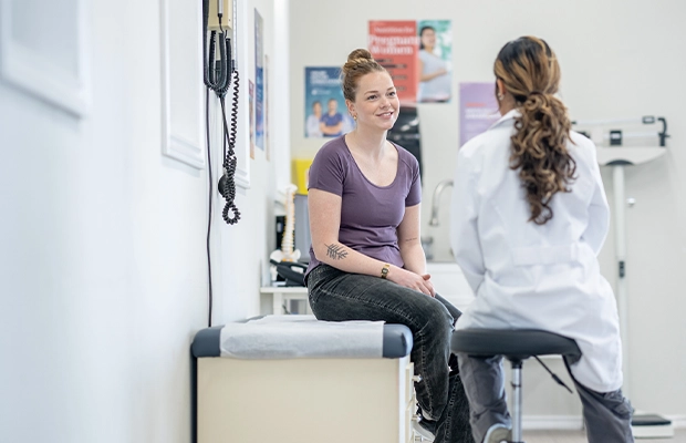 woman talking to a doctor while sitting on a stretcher