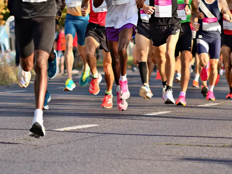 Lower middle shot of several people running in a marathon.
