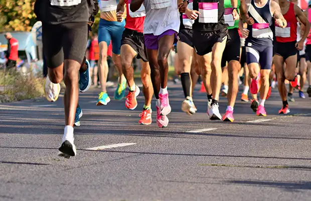 Lower middle shot of several people running in a marathon.