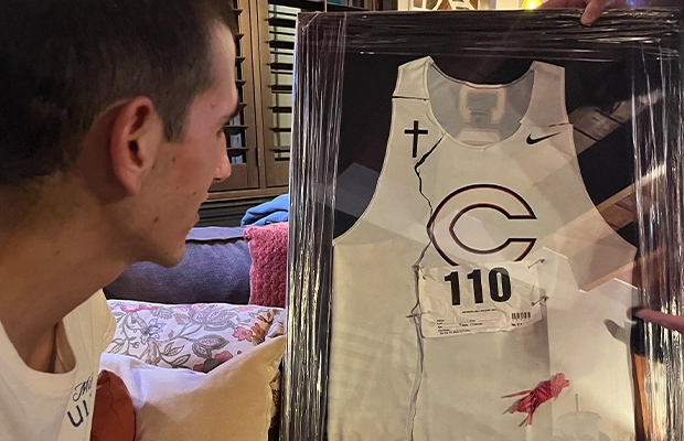 young man looking at a framed team jersey