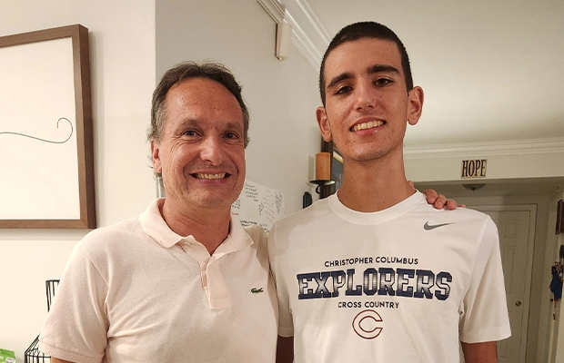 man and young man hugging smiling
