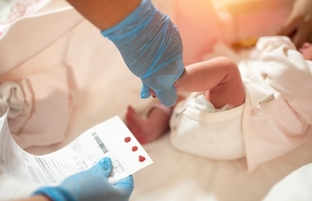 Nurse taking sample from newborn baby