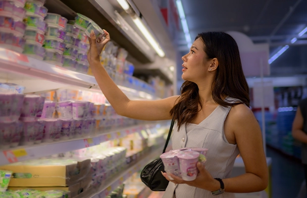 woman selecting products from a supermarket refrigerator