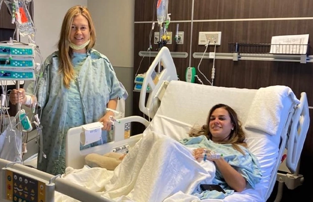 Blonde woman standing next to a stretcher where another woman is lying
