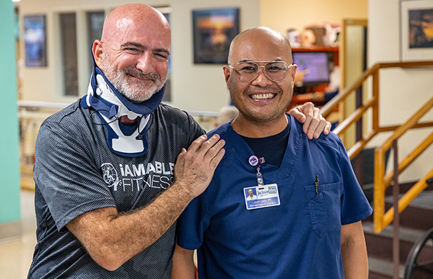 Ed Navarro smiling next to a Jackson Health System employee