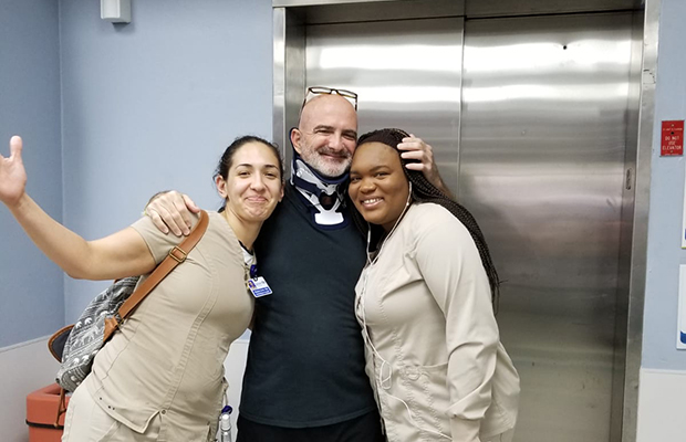 Ed Navarro smiling and posing with two Jackson Health System employees