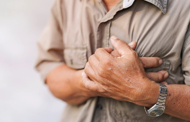 Close-up of a man's hands holding his chest as if he were about to have a heart attack