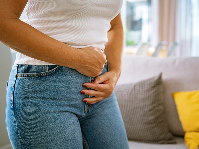 Close-up of a woman clutching her belly as if in severe pain