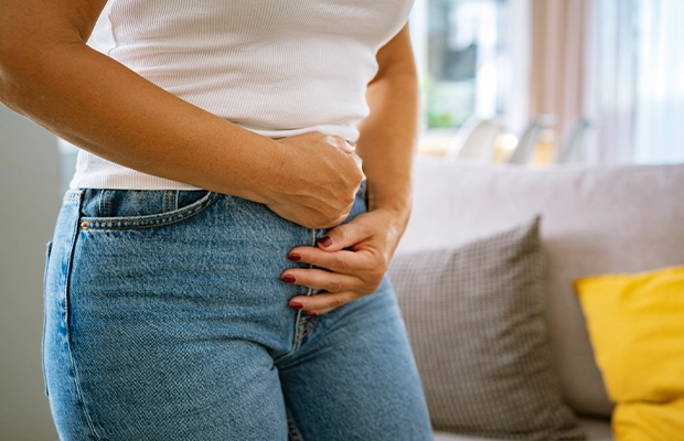 Close-up of a woman clutching her belly as if in severe pain
