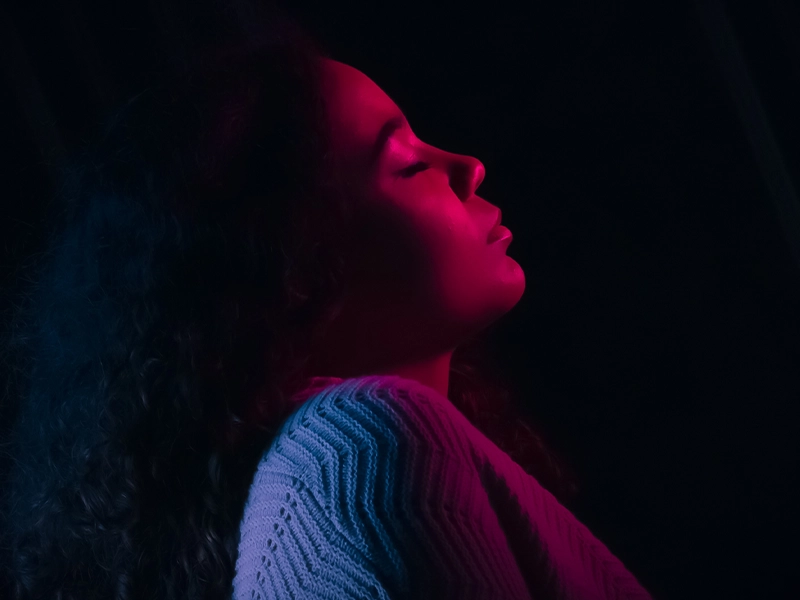 Image of a woman in low profile, colored lights