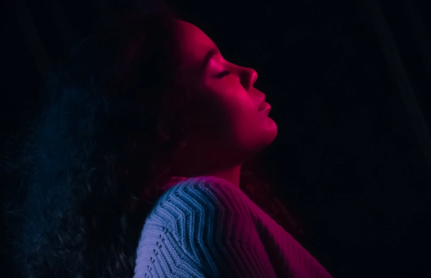 Image of a woman in low profile, colored lights