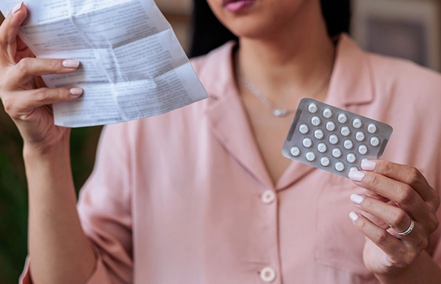 Close-up of a woman's hands showing pills to the camera