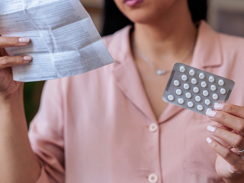 Close-up of a woman's hands showing pills to the camera