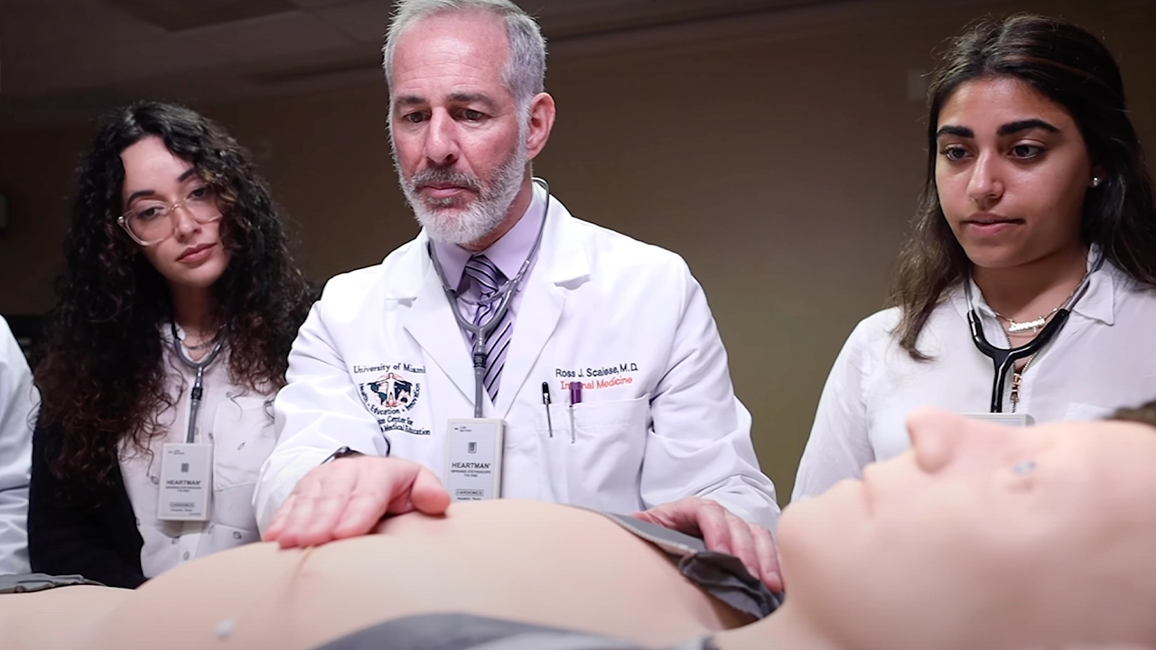 A doctor doing a demonstration in front of two women