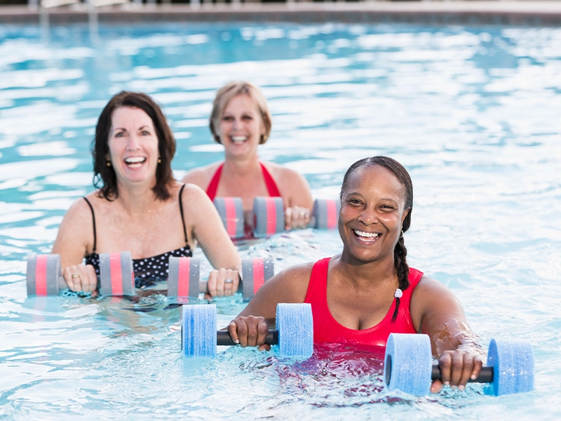 three women using weights inside the pool