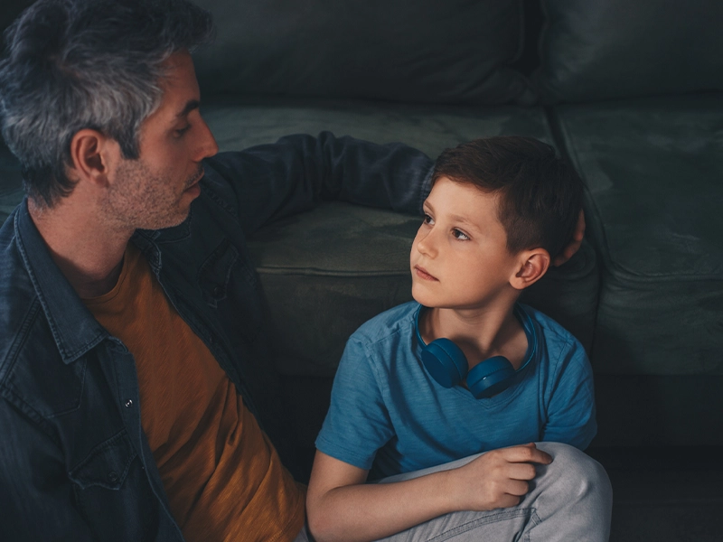 photo of man and boy talking