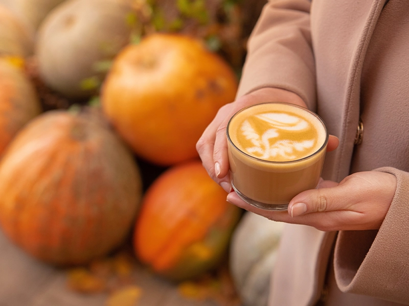 image showing hands with a glass full of a pumpkin-based drink